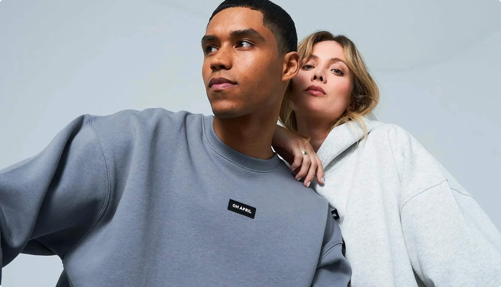 Man in grey sweatshirt, woman in light grey hoodie.