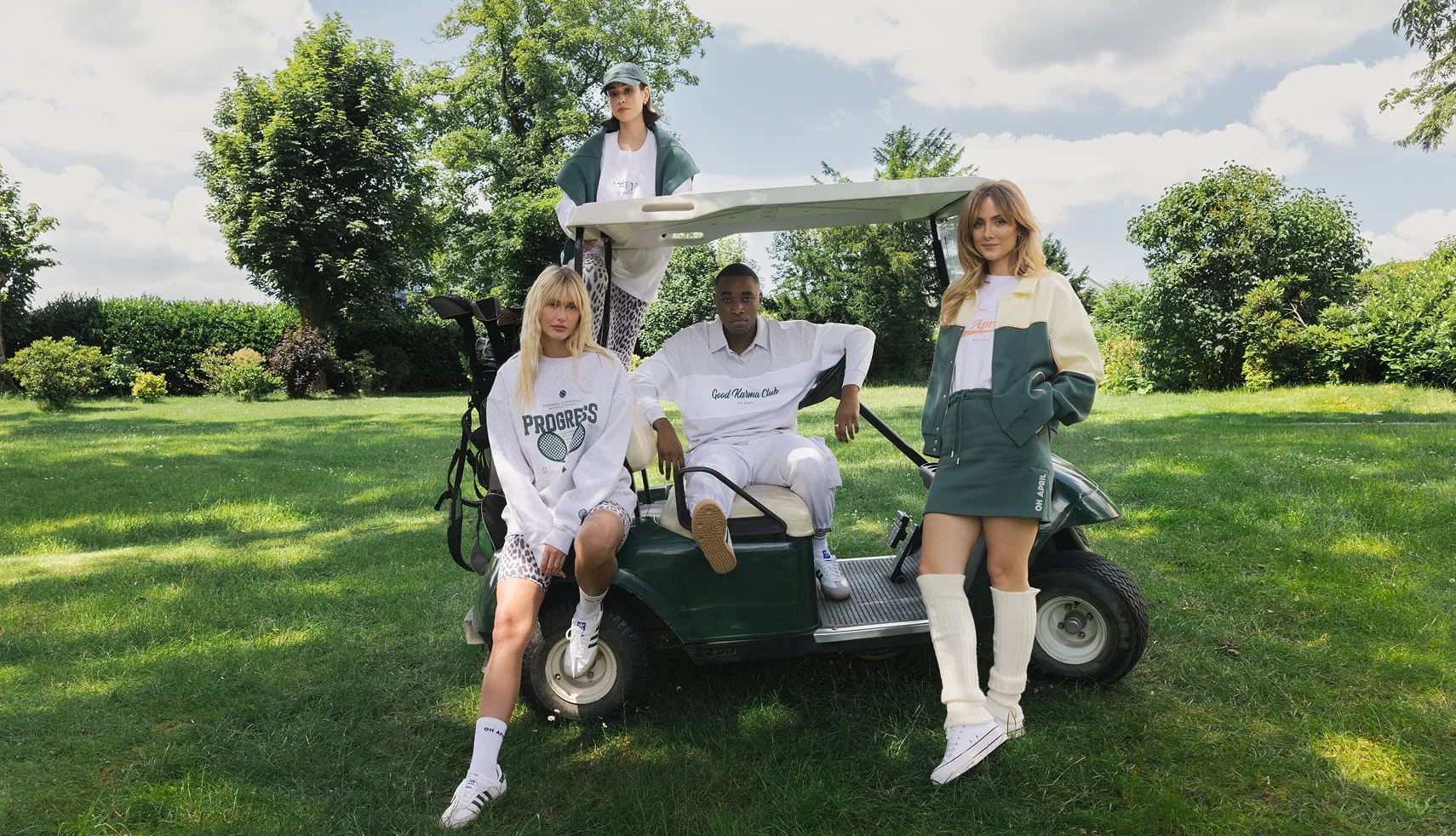 OH APRIL campaign: four models in white and green sporty looks around a golf cart on a lawn