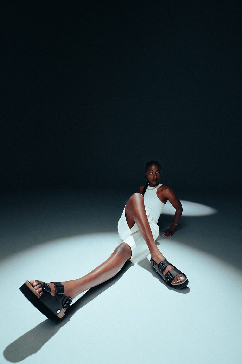 Model in white outfit and sandals.