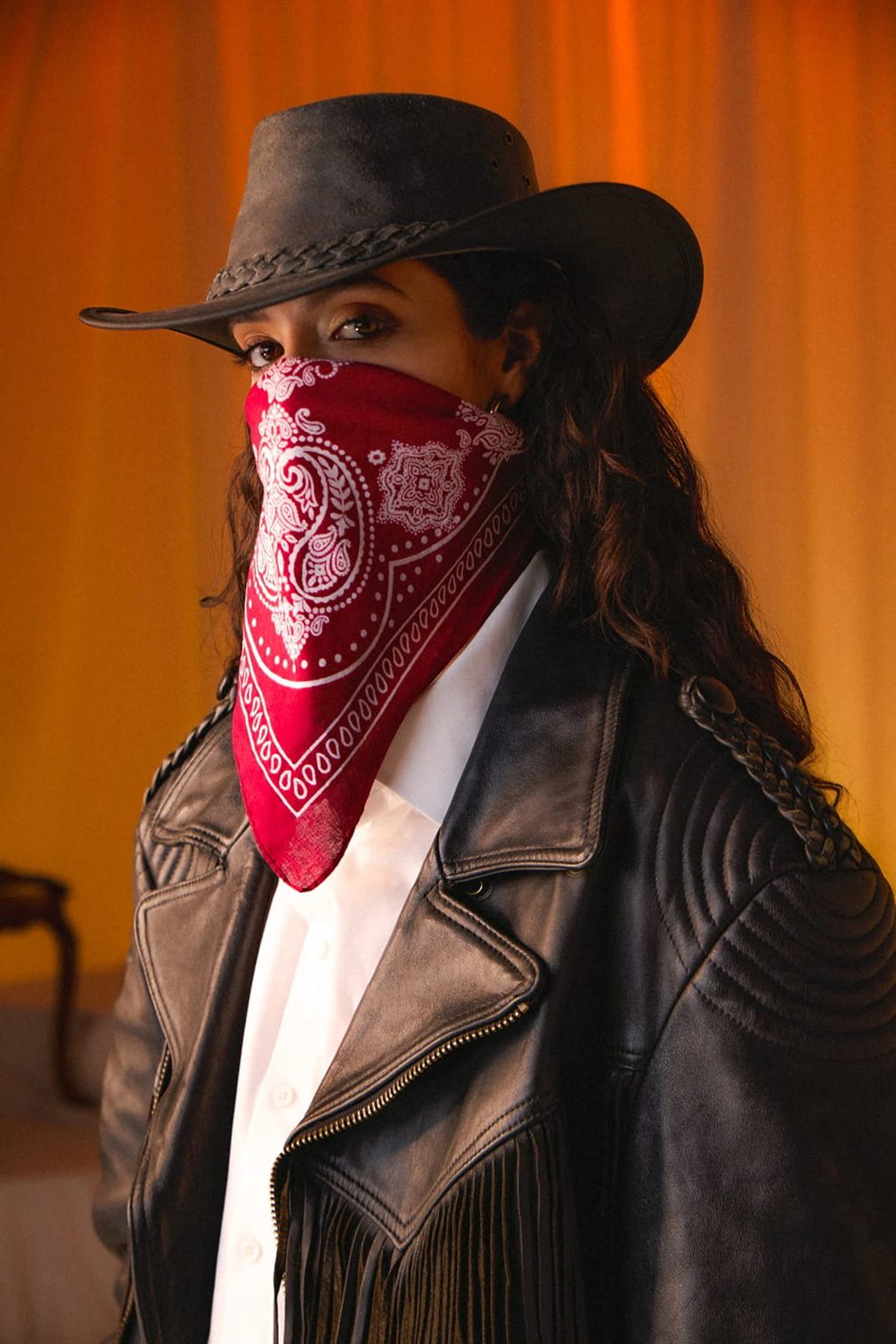 Frau mit Cowboyhut, Gesichtsmaske und Lederjacke.