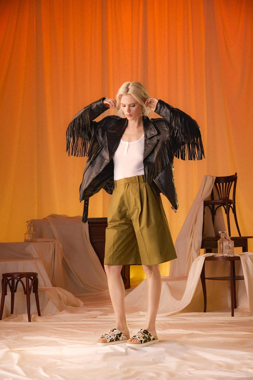 Frau in Fransenjacke und olivfarbenen Shorts
